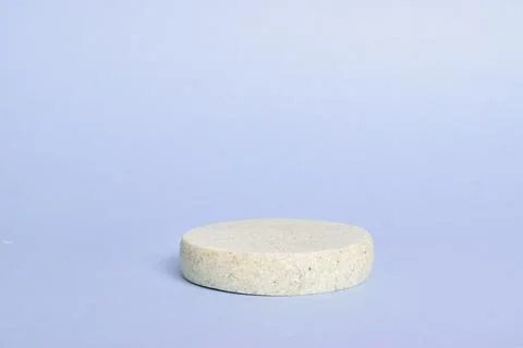 Minimalistic scene of a lying stone on a light purple background Stock Photos