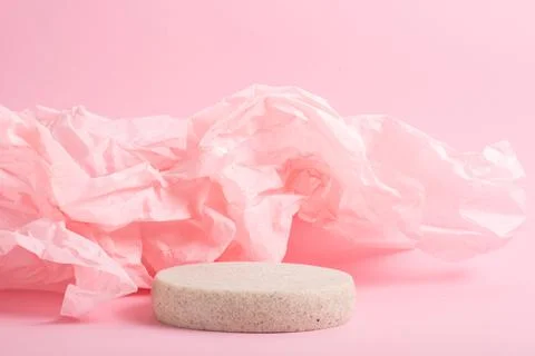 Minimalistic scene of a lying stone on a light pink abstract background. Stock Photos