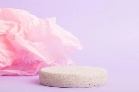 A minimalistic scene of a lying stone on a light purple background with mint  Stock Photos