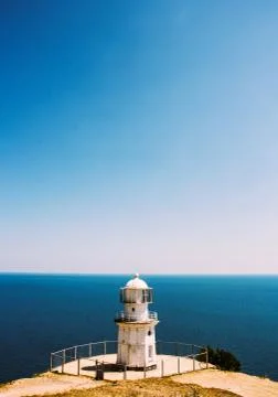 Minimalistic summer landscape with lighthouse and sea Stock Photos