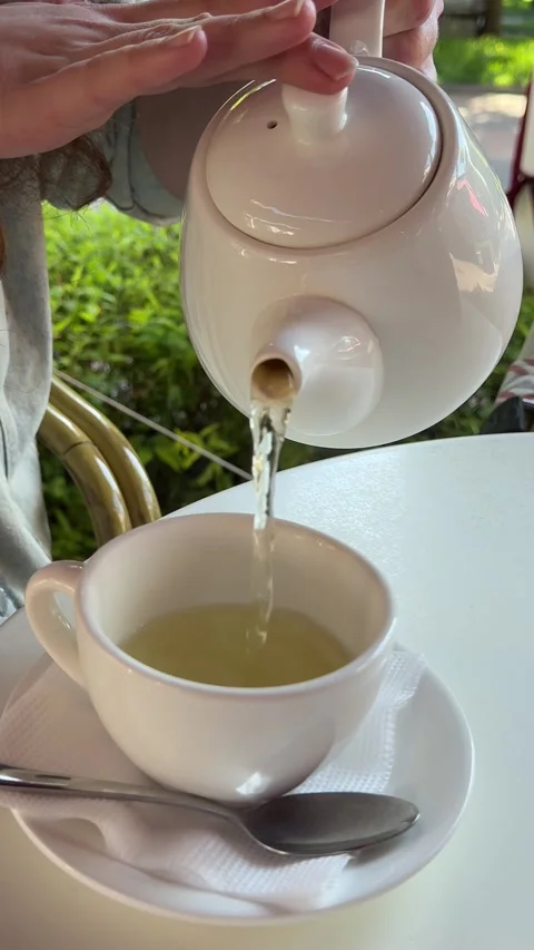 Minimalistic white tea service on bright tablecloth in outdoor coffee place Stock Footage 345737533
