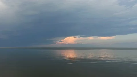 Minimalized scene of a calm lake in the evening with one sun lite cloud  Stock Footage 212088364