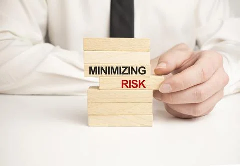 Minimizing risks words on wooden blocks on yellow background. Business ethics Stock-Fotos