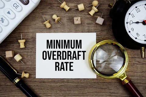 Minimum Overdraft Rate text written on notepad with pen, alarm clock, magni.. Stock Photos