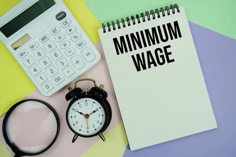 Minimum Wage text with calculator, alarm clock and magnifying glass Busines.. Foto stock