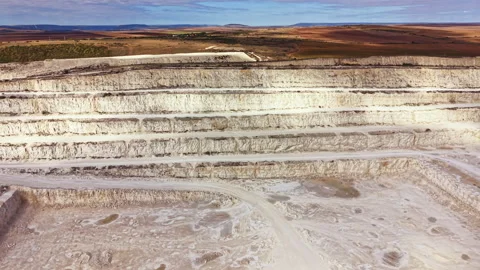 Mining activity in a large quarry in a rural area surrounded by fields and hills Stock Footage 345455355
