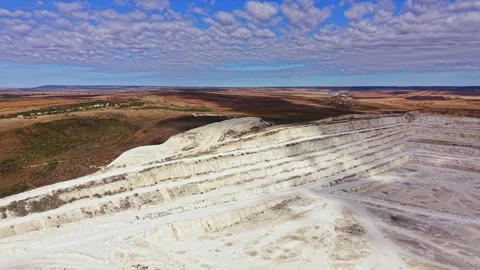 Mining activity in a large quarry showing layered structures and a vast Stock Footage 345455234