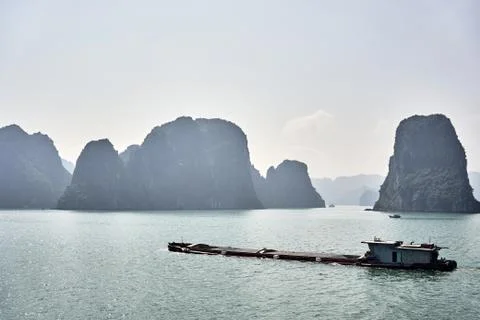 Mining barge carrying materials between the rock formations at the Ha Long Ba Stock Photos