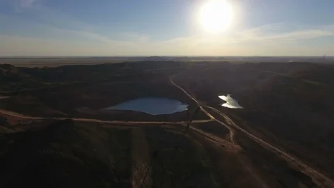 Mining boom. Excavator loads ore.Panorama. Artificial lake. Sunset. Development Stock Footage 73455975