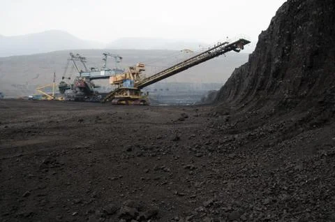 Mining of coal in the open pit mine with heavy machinery Stock Photos