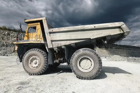 Mining dump truck against the background of a quarry and a sky w Stock Photos