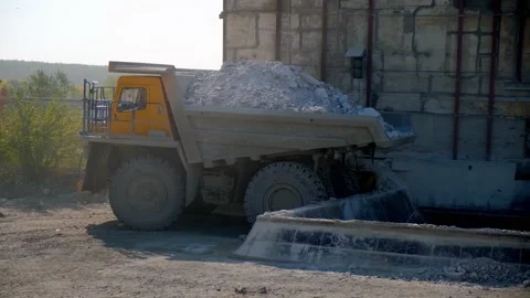 The mining dump truck backs up and pours the stone into the bunker. Side view Stock Footage 212365354