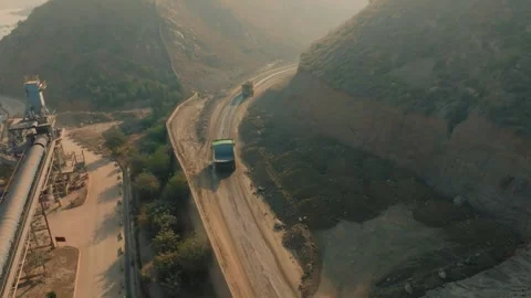 Mining dump truck driving on quarry road near industrial plant Stockbeeldmateriaal 332900597