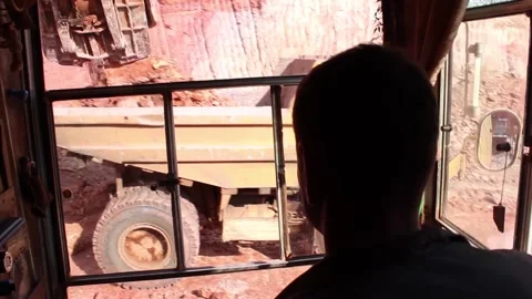 A mining dump truck pulls up to load, a mining excavator picks up soil in the Stock Footage 122218050