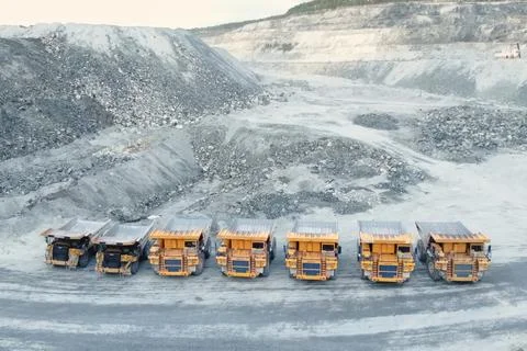 Mining dump trucks are parked in row. Equipment for an industrial quarry. Stock Photos