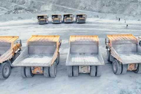 Mining dump trucks are parked in row. Equipment for an industria Stock Photos