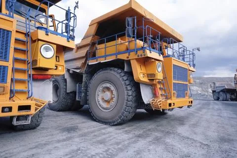 Mining dump trucks are parked in row. Equipment for an industrial quarry. Stock Photos