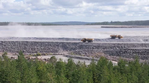 Mining dump trucks drive past each other on open cast mine in Europe, aerial Video stock 299777427