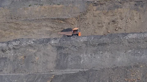 Mining dump trucks in the open pit mine. The dump truck goes on the Stock Footage 94480574