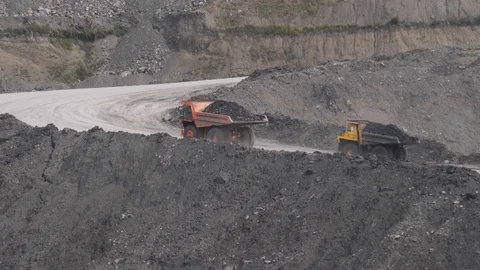 Mining dump trucks in the open pit mine. Loaded truck rides on the road quarry Vidéo 94481197