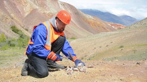 A mining engineer or geologist wearing gloves, a helmet, a reflective waistcoat Stock Footage 79475886