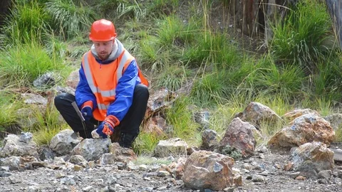 A mining engineer or geologist wearing gloves, a helmet, a reflective waistcoat Stock Footage 83498271