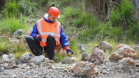 A mining engineer or geologist wearing gloves, a helmet, a reflective waistcoat Stock Footage 83499176