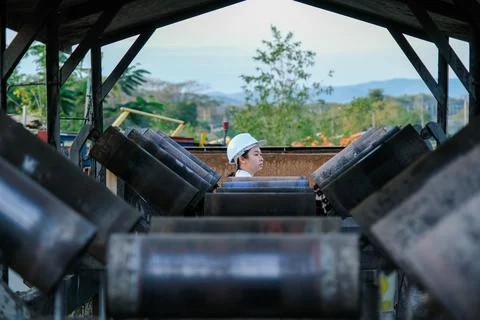 Mining engineer wearing a white helmet surveying her work place. Stock Photos