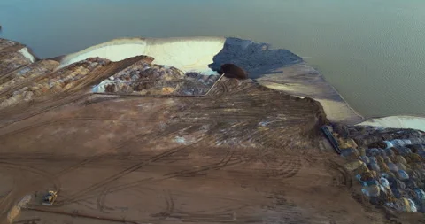 Mining equipment pumping water and sand through metal pipe at open phosphate pit Stock Footage 329141869
