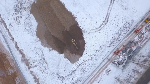 Mining excavator digging hole in snowy ground on industrial area drone view Stock Footage 86854269
