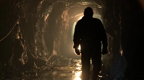 Mining men walking in the tunnel towards bulldozer Stock Footage 52816968