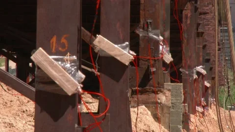 Mining of a metal structure with a red dynamite block TNT. Blasting Specialists Stock Footage 138831736