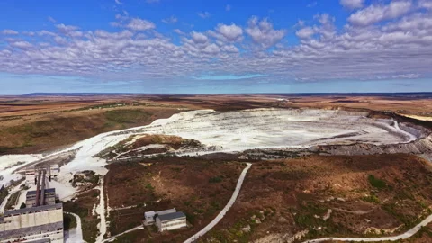 Mining operations take place in an open pit with machinery and access roads Stock Footage 345454988