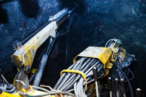 Mining operator on mining machine, underground mine mesh. 库存照片