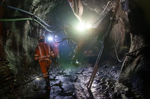 Mining operator on mining machine, underground mine mesh. 库存照片