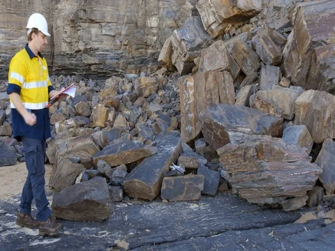 Mining prospect mineral exploration Geologist looking at sedimentary rock Video stock 78593389