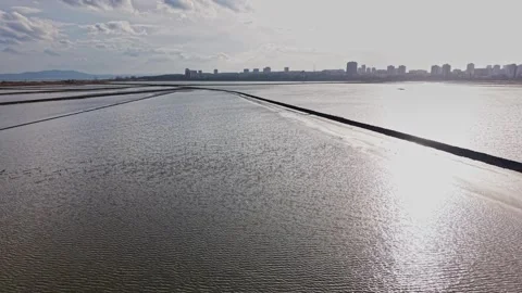 Mining salt in large pools near a city during late afternoon Stock-Footage 335140976