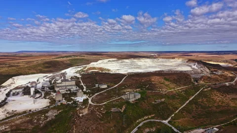 Mining site with machinery and open pit located in a vast area with blue sky and Stock Footage 345454839
