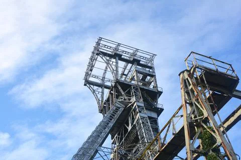 Mining tower in front of a blue sky with white clouds Stock Photos