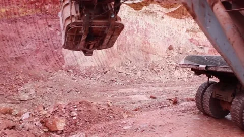 A mining truck pulls up for loading, a mining excavator takes the soil Stock Footage 122217792