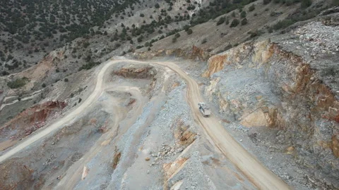 A mining vehicle navigates the rugged terrain of a quarry in this aerial view Stock Footage 314842488