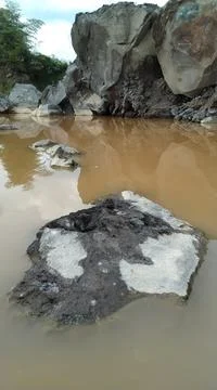 Mining waste rock on the river side Stock Photos