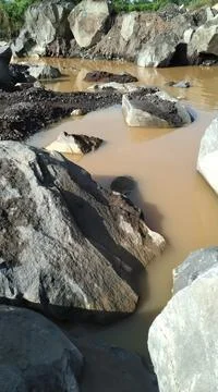 Mining waste rock on the river side Stock Photos