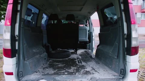 A minivan car with an open trunk leaves the parking lot near the house Stock-Footage 149997963