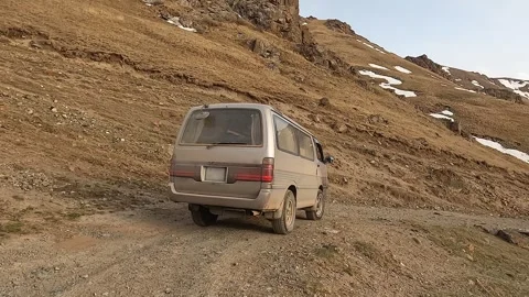 The minivan is driving down a mountain dirt rocky road Stock Footage 241381817
