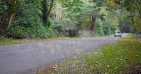 Minivan entering frame on road causing dotted binary overlay showing tech data, Foto stock