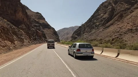 A minivan overtakes a passenger car on a mountain road Stock-Footage 241381806
