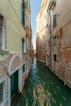 Minor side canal between two ancient buildings in Venice, Italy Stock Photos