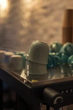 Mint ceramic espresso cups on machine warming tray in cafe Stock Photos