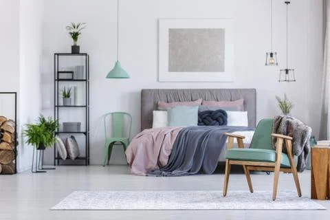 Mint chair next to bed 스톡 사진